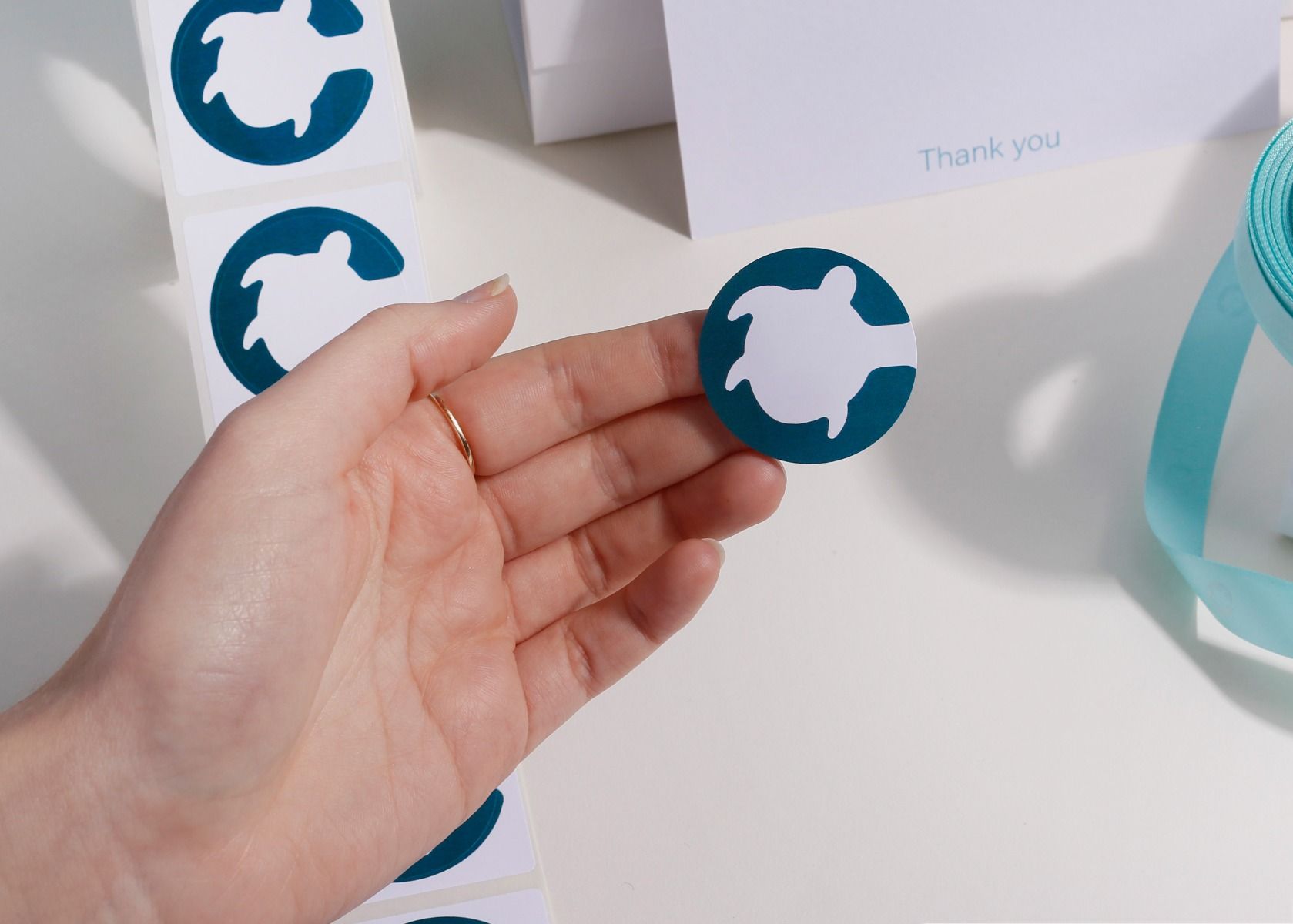 Branded printed stickers coordinated with boxes, tissue and other packaging details.
