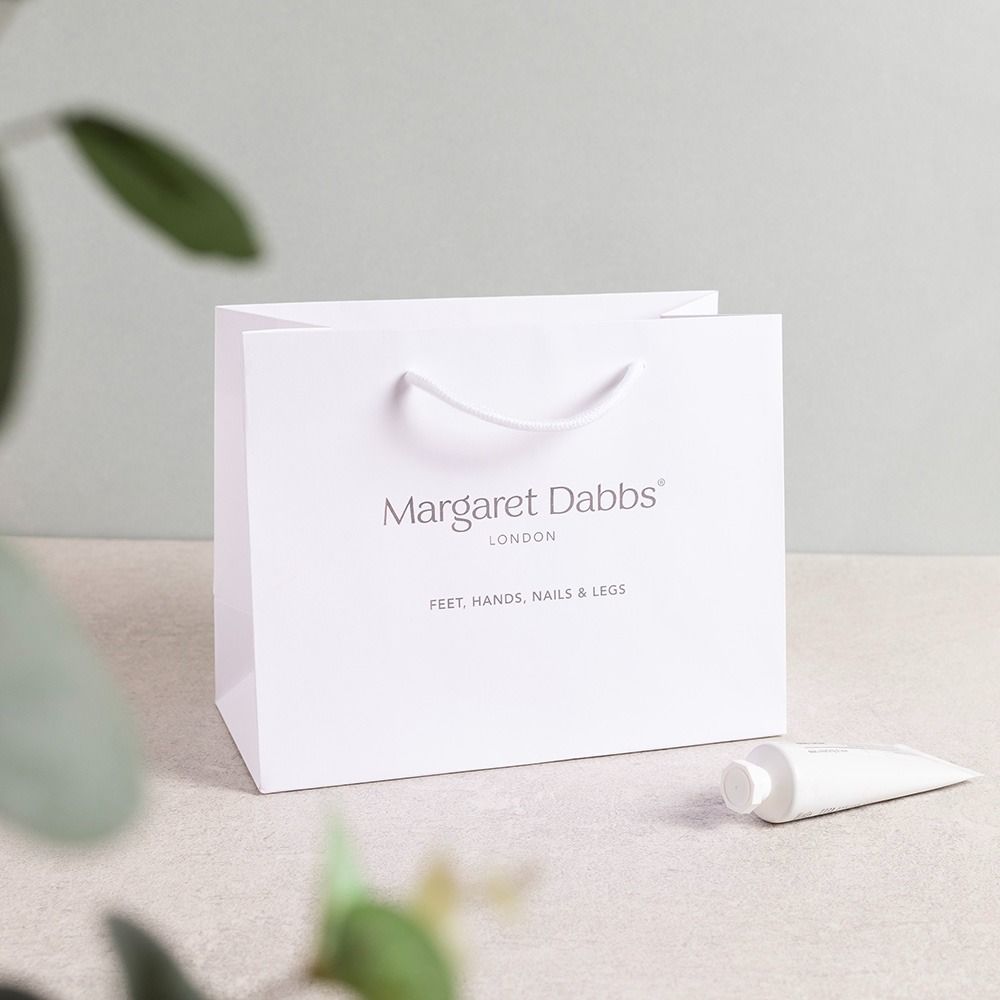Luxury branded gift bags with carefully positioned handles and clear front-panel branding.