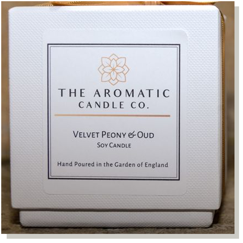 square white candle box with a label on the front from the aromatic candle company